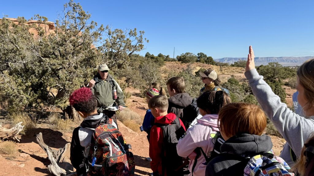 Volunteer Ranger leads a group of kids outdoors for learning opportunities within Colorado National Monument. 